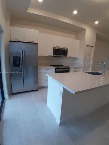 a kitchen with stainless steel appliances a sink stove and microwave