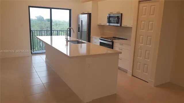 a kitchen with stainless steel appliances granite countertop a sink and a refrigerator