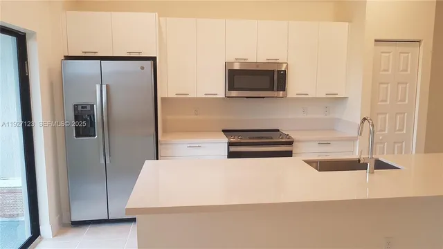 a kitchen with stainless steel appliances a refrigerator a stove and a cabinets