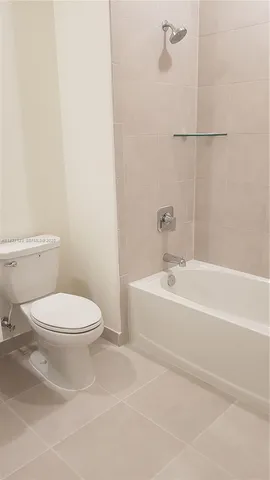 a white toilet sitting next to a bathroom sink