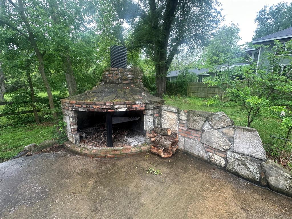 504 1st Street Terrell, TX 75160 - Photo 23 of 27 Outdoor stone and brick fireplace with chimney, situated on a concrete patio