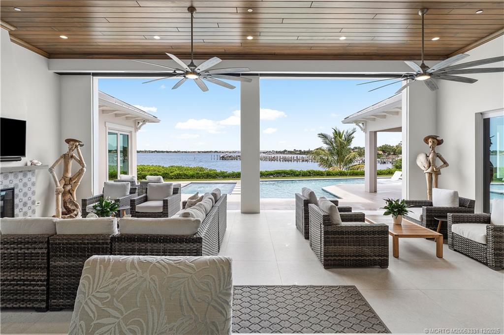 2842 Southwest Rivers End Way Palm City, FL 34990 - Photo 18 of 99 a living room with patio furniture and a floor to ceiling window