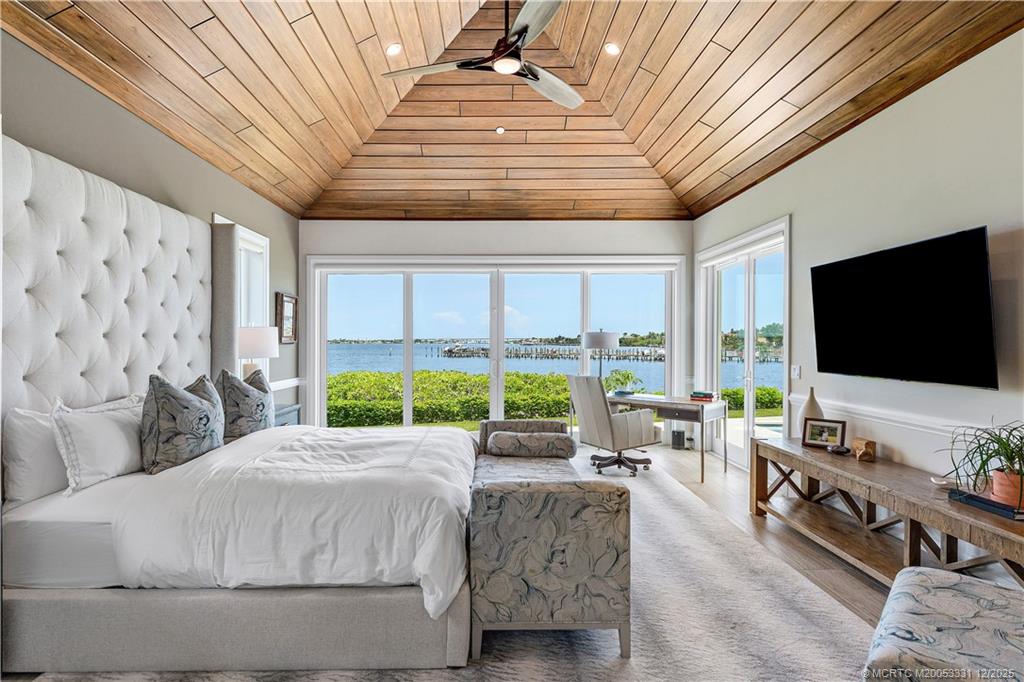 2842 Southwest Rivers End Way Palm City, FL 34990 - Photo 32 of 99 a living room with large window and a flat screen tv