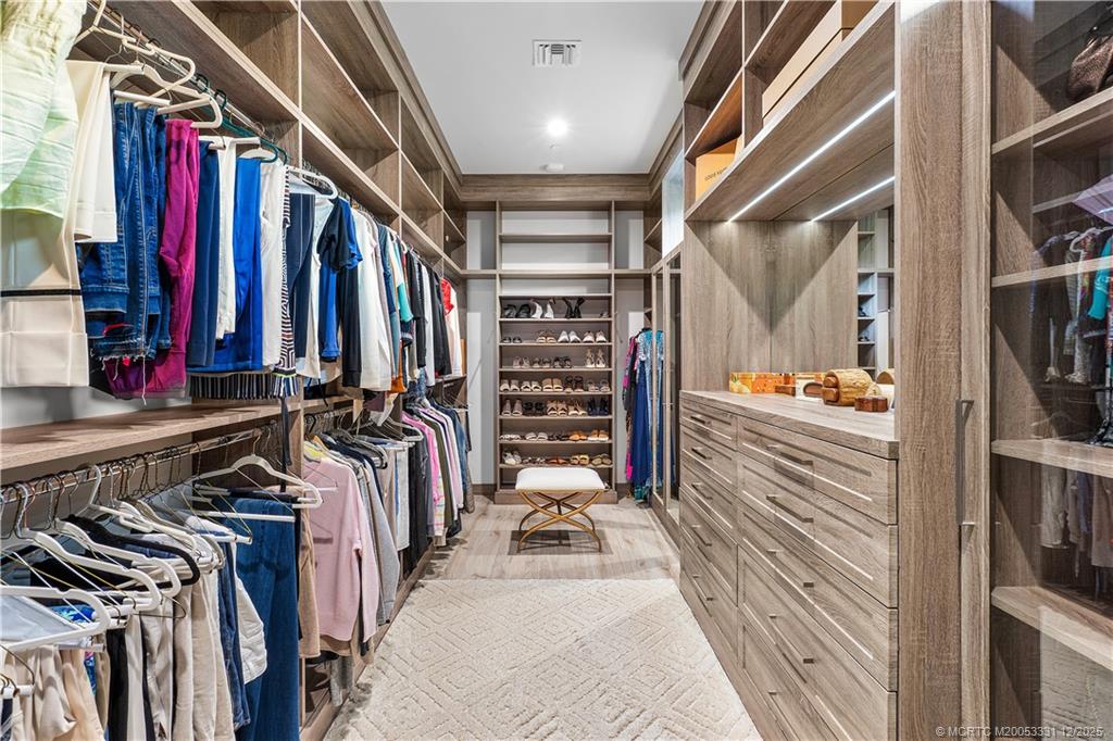 2842 Southwest Rivers End Way Palm City, FL 34990 - Photo 35 of 99 a view of walk in closet with clothes and shoes