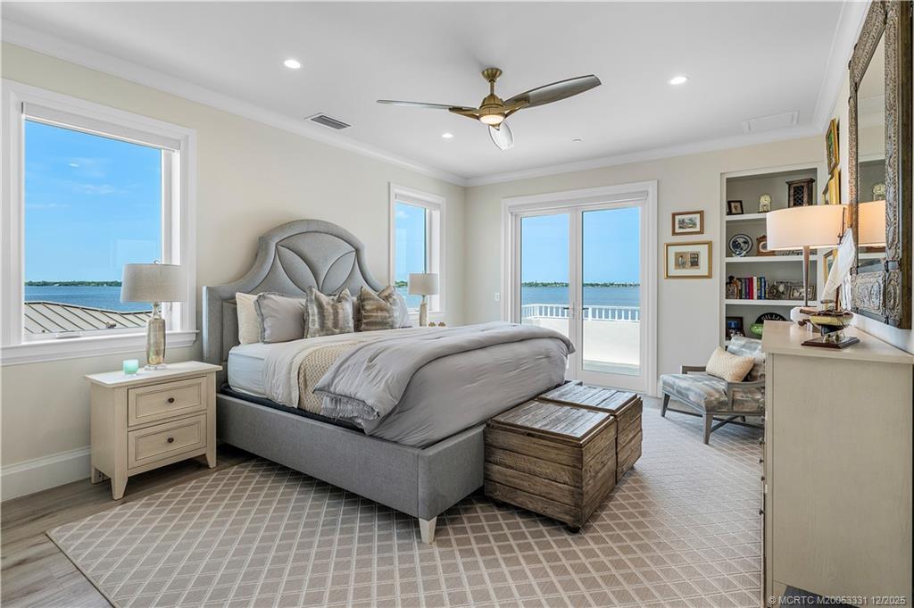 2842 Southwest Rivers End Way Palm City, FL 34990 - Photo 43 of 99 a bedroom with a large bed and a chandelier