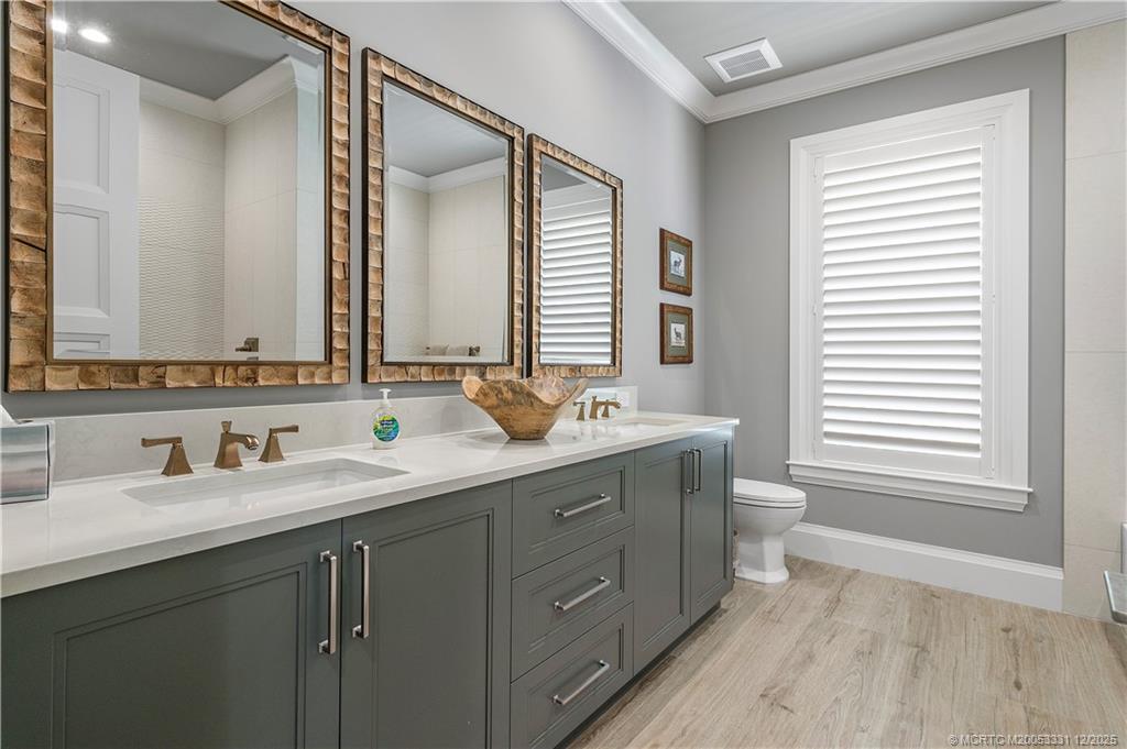 2842 Southwest Rivers End Way Palm City, FL 34990 - Photo 44 of 99 a bathroom with a double vanity sink a mirror and a window