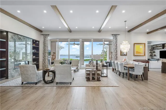 a living room with furniture wooden floor and a floor to ceiling window