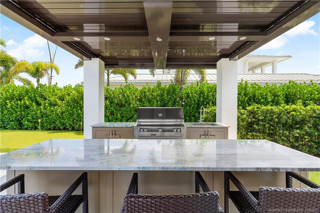 2842 Southwest Rivers End Way Palm City, FL 34990 - Photo 71 of 99 a view of outdoor kitchen with dining table and chairs