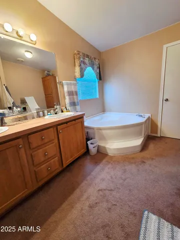 a spacious bathroom with a granite countertop sink and a mirror