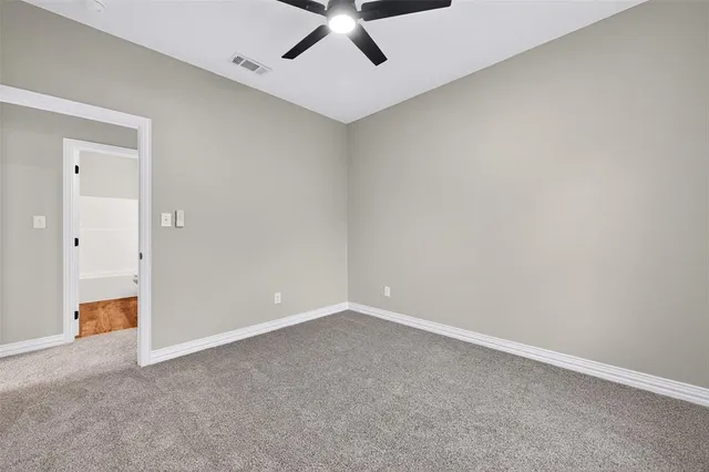 an empty room with a window and a ceiling fan