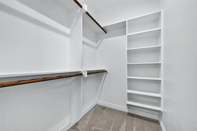 an empty room with closet and a ceiling fan