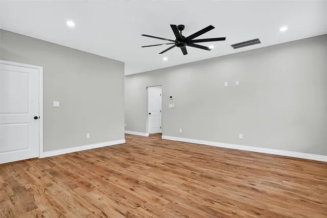 a view of a big room with wooden floor and windows