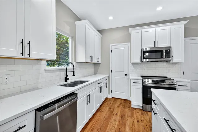 a kitchen with a sink a stove and a microwave