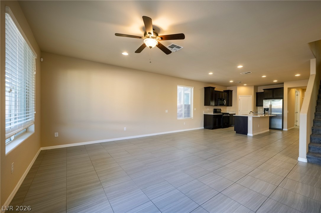 11016 Prairie Grove Road Las Vegas, NV 89179 - Photo 10 of 37 An open-concept living area with tiled flooring seamlessly connects to the kitchen.