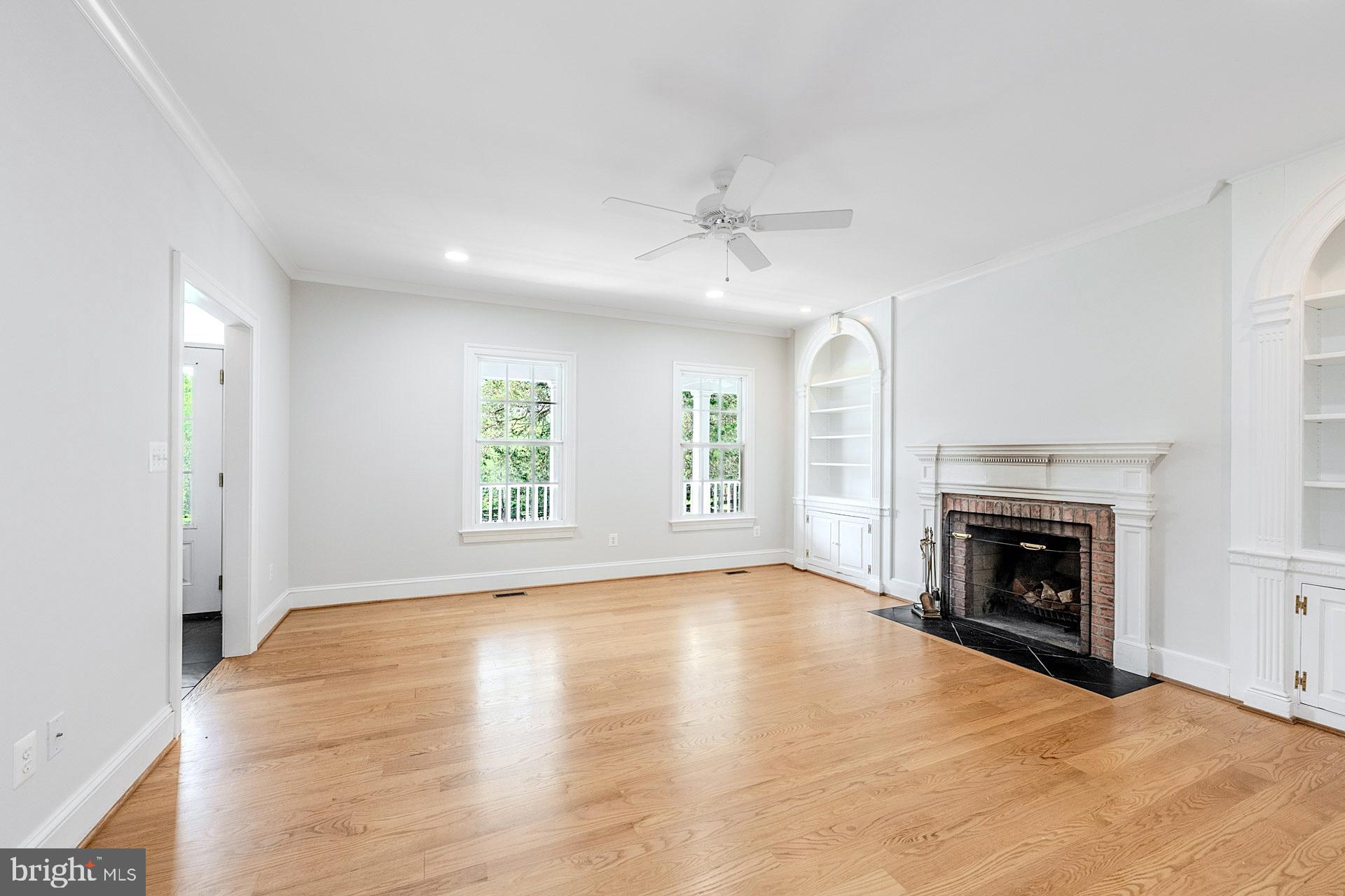 11208 West Montpelier Road Great Falls, VA 22066 - Photo 19 of 77 an empty room with windows fireplace and wooden floor