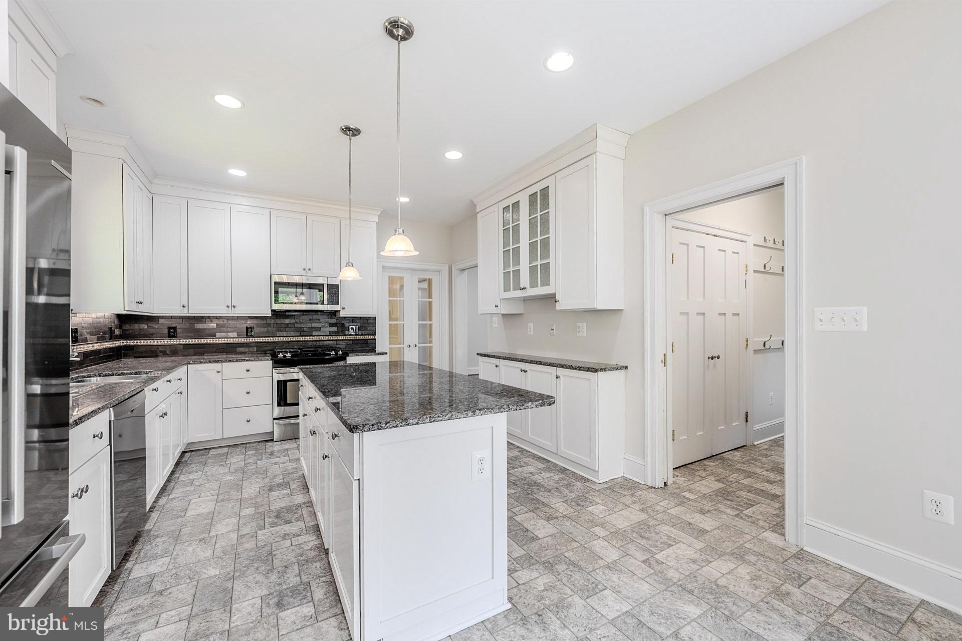 11208 West Montpelier Road Great Falls, VA 22066 - Photo 25 of 77 a kitchen with white cabinets and refrigerator