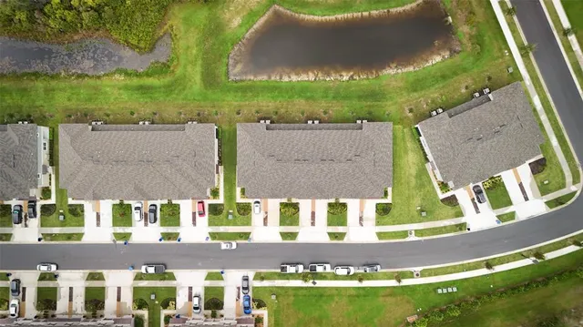 an aerial view of a house with a garden and lake view