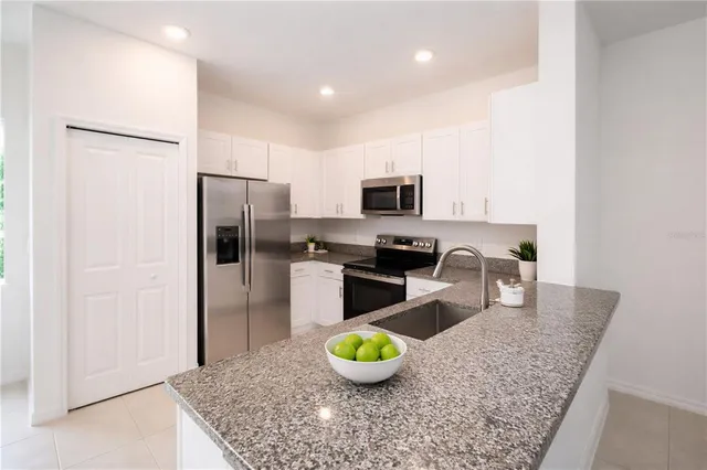 a kitchen with a refrigerator a stove and a sink