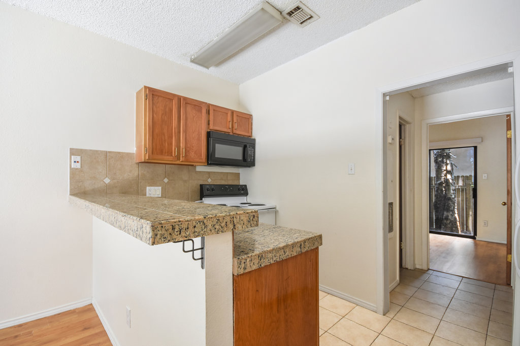 2815 Rio Grande Street, Unit 104 Austin, TX 78705 - Photo 12 of 22 a kitchen with stainless steel appliances a sink a stove a microwave a counter top space and cabinets