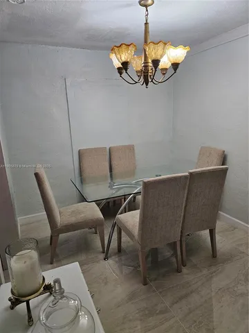 a dining room with furniture a chandelier and window