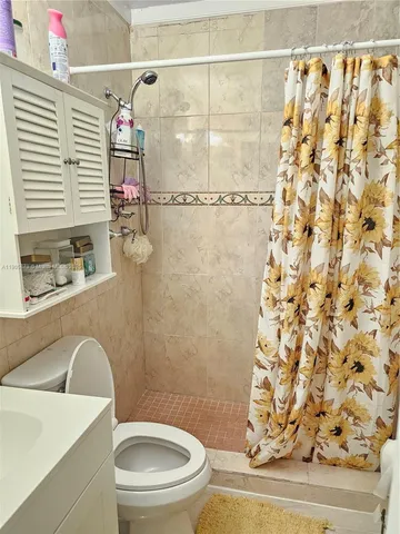 a white toilet sitting next to a shower curtain