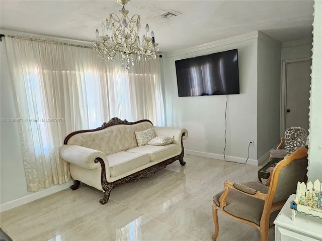 a living room with furniture and a chandelier