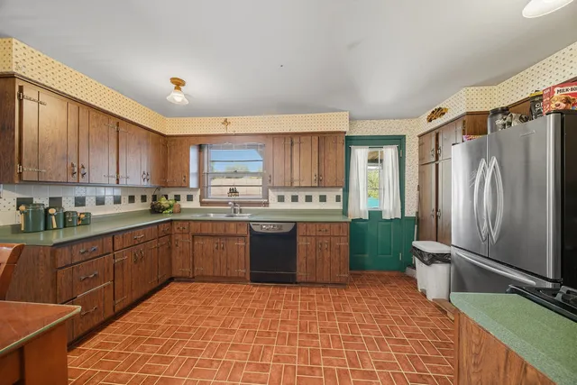 a kitchen with stainless steel appliances granite countertop a refrigerator sink and cabinets