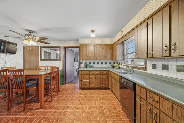 a kitchen with stainless steel appliances granite countertop a stove top oven a sink dishwasher and cabinets