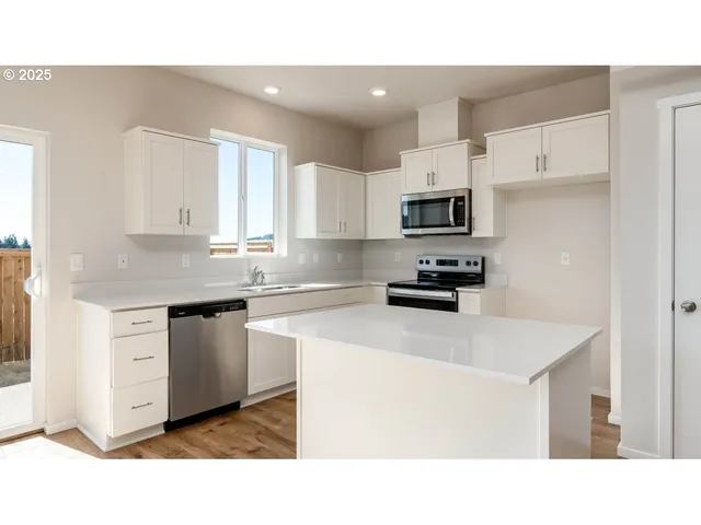 a living room with stainless steel appliances kitchen island a cabinets and wooden floor