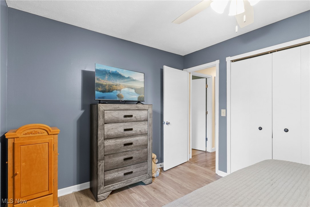 7944 Middle Ridge Road Madison, OH 44057 - Photo 22 of 31 Bedroom featuring light wood-style floors, a ceiling fan, and a closet