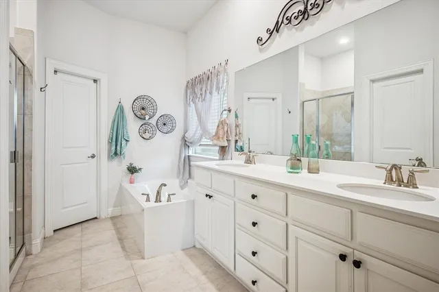 a spacious bathroom with a double vanity sink mirror and bathtub