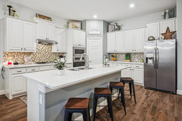 a kitchen with appliances a sink and cabinets
