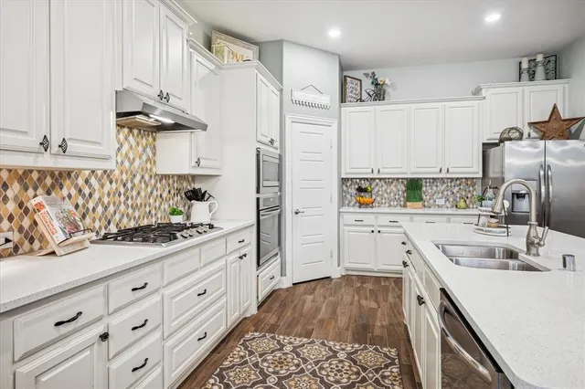 a kitchen with granite countertop a sink stove and refrigerator