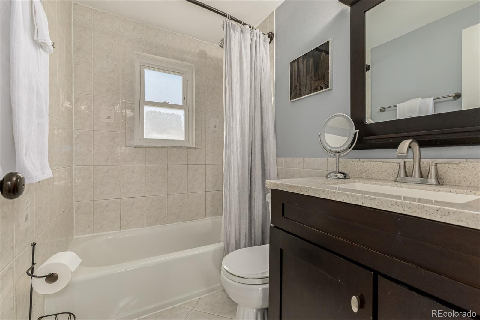 11875 Spring Drive Northglenn, CO 80233 - Photo 16 of 29 a bathroom with a sink a toilet a mirror and shower