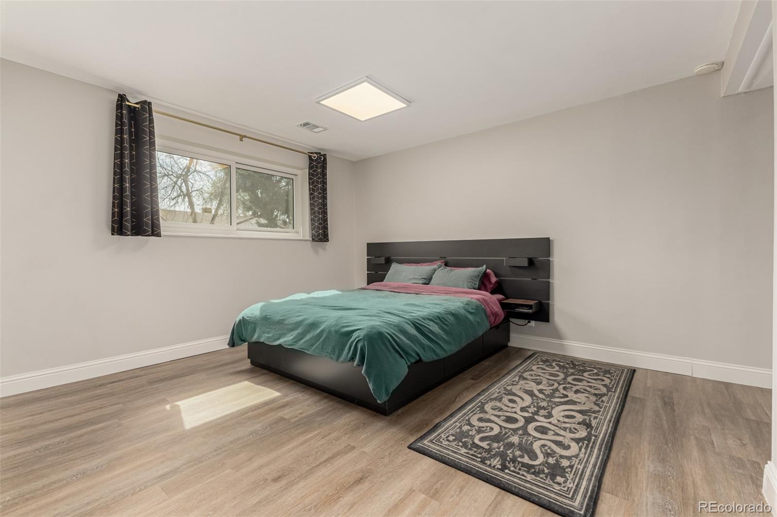 11875 Spring Drive Northglenn, CO 80233 - Photo 17 of 29 a bedroom with a bed rug and wooden floor