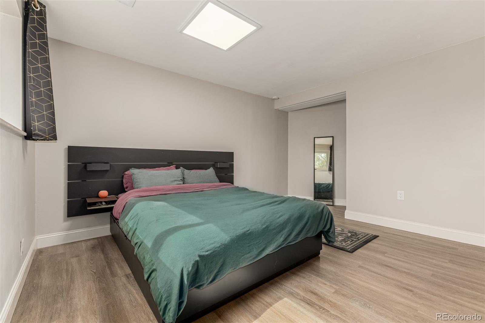 11875 Spring Drive Northglenn, CO 80233 - Photo 18 of 29 a bedroom with a bed and wooden floor