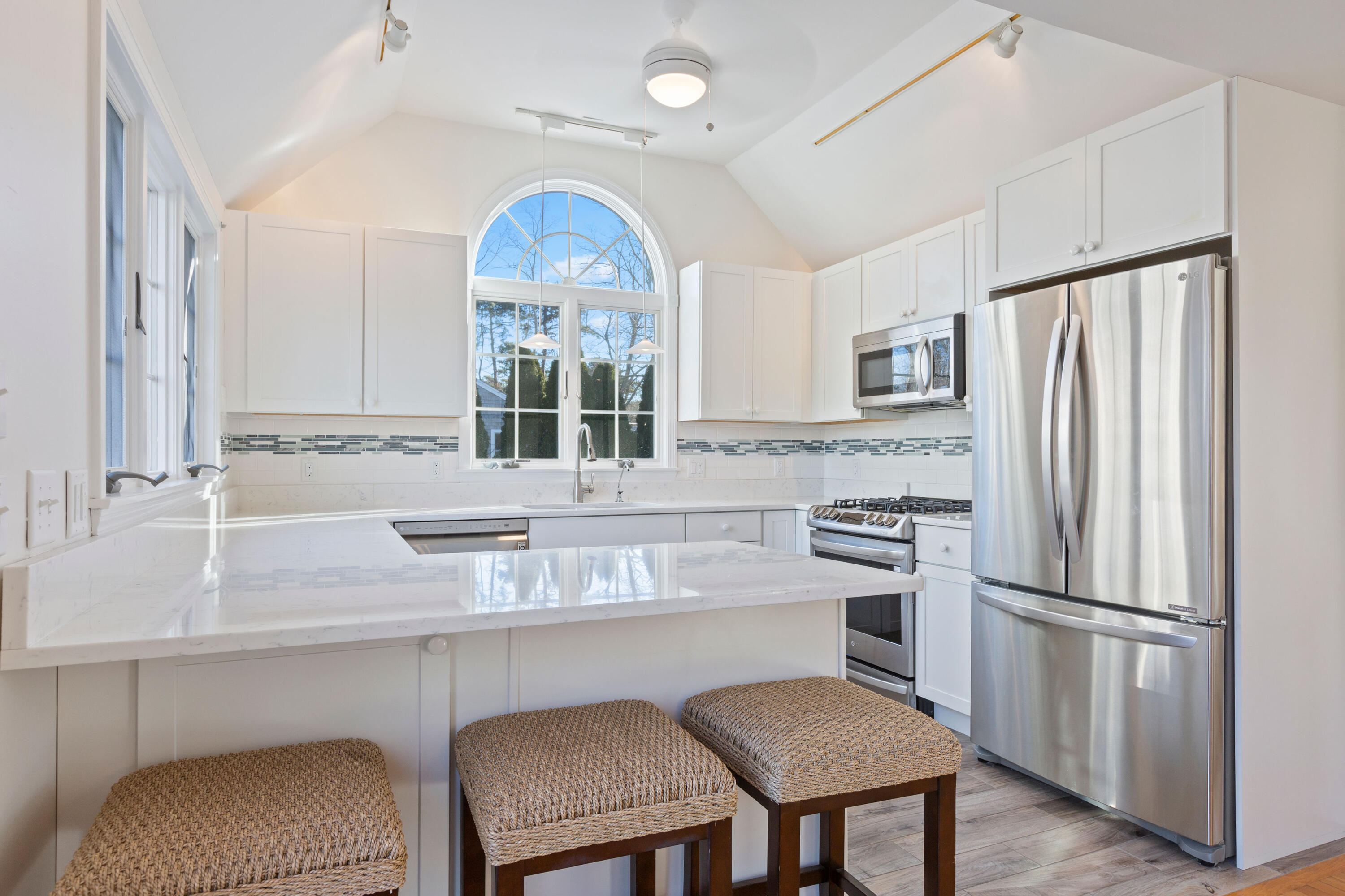 220 Hay Road Eastham, MA 02642 - Photo 14 of 54 a kitchen with stainless steel appliances granite countertop a table chairs refrigerator and sink