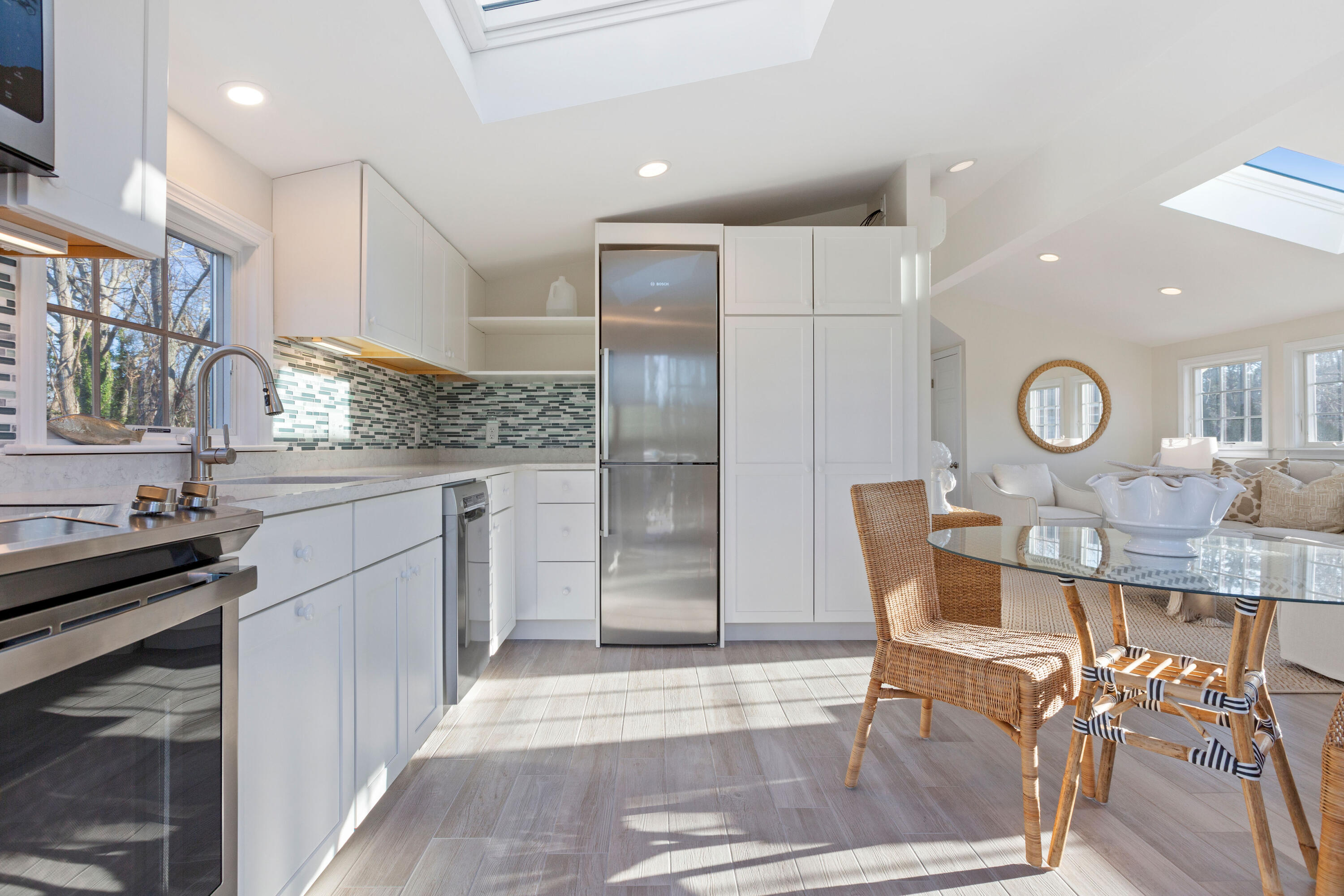 220 Hay Road Eastham, MA 02642 - Photo 39 of 54 a kitchen with stainless steel appliances kitchen island granite countertop a table chairs in it and wooden floors
