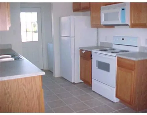a kitchen with a stove cabinets and utility