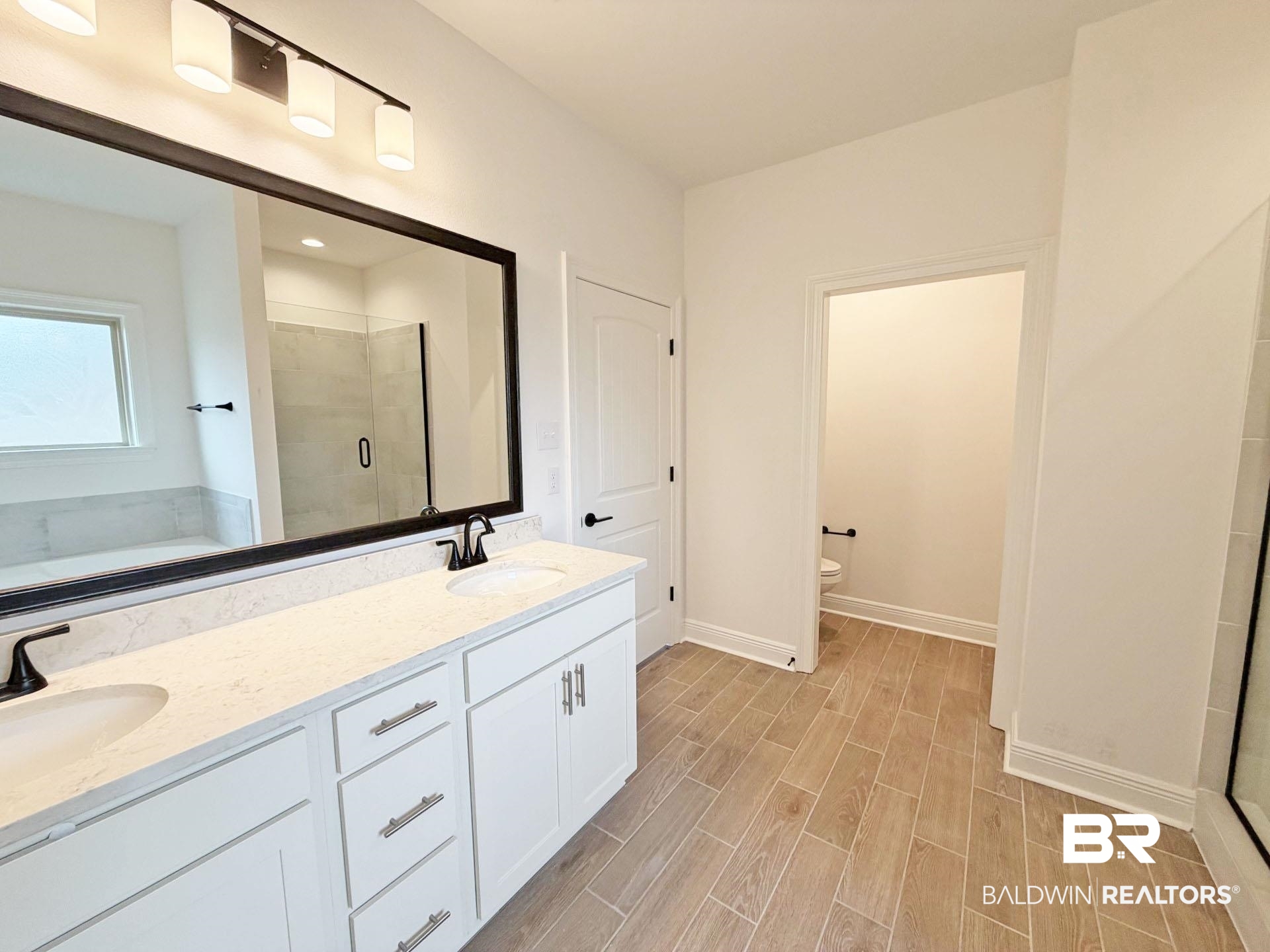 1753 Breckinridge Place Foley, AL 36535 - Photo 11 of 24 Dual vanity with white cabinetry, light-toned countertops, and matte black fixtures