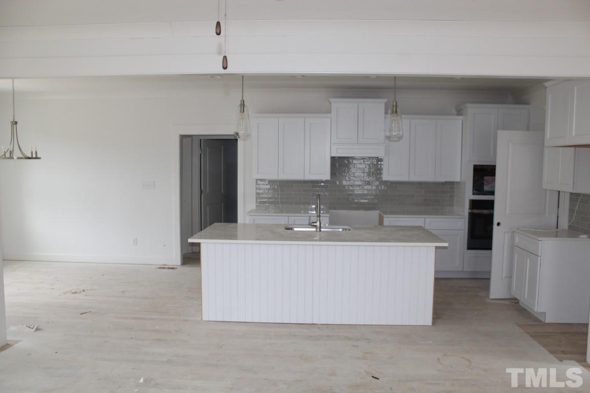 328 Prides Crossing Rolesville, NC 27571 - Photo 2 of 23 a large kitchen with kitchen island a sink a stove a refrigerator and white cabinets