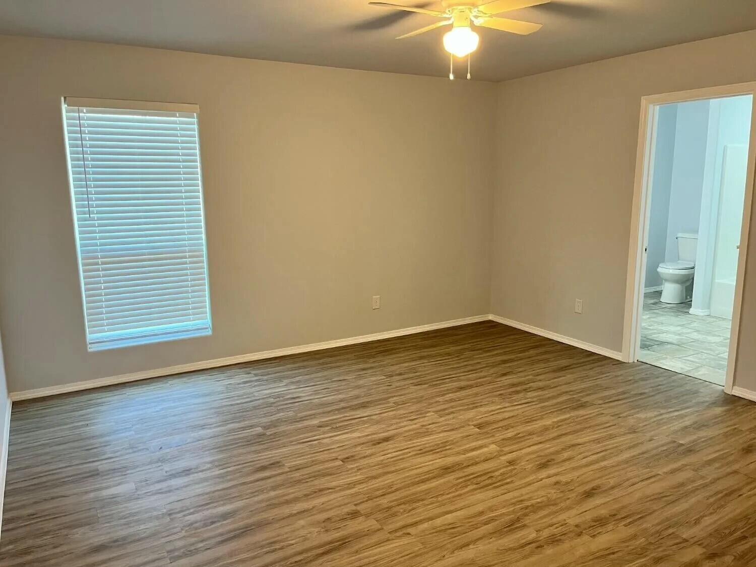 8419 10th Place Lubbock, TX 79416 - Photo 5 of 11 a view of an empty room with wooden floor and a window