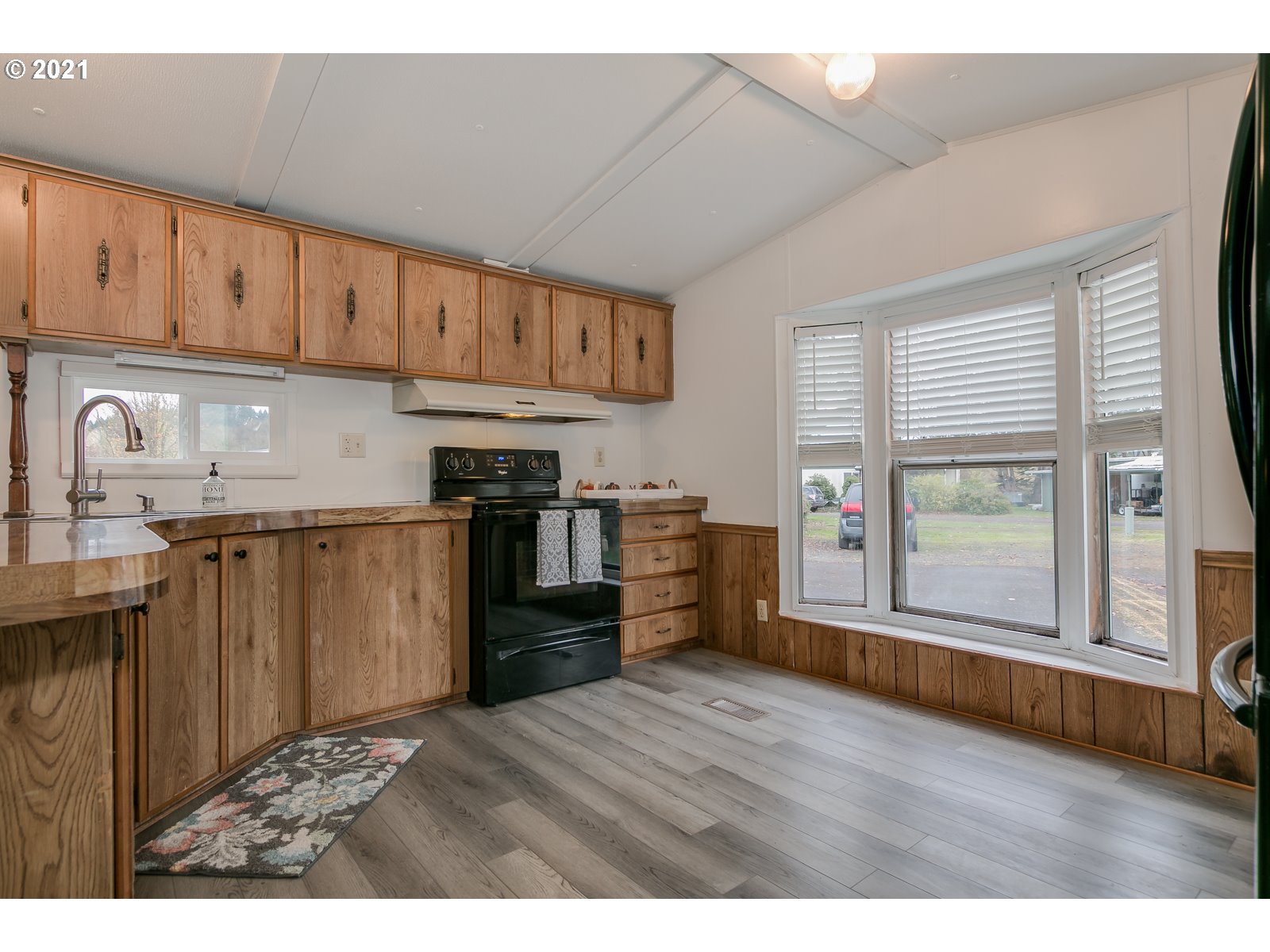 7080 Thurston Road, Unit SP 12 Springfield, OR 97478 - Photo 13 of 22 a kitchen with stainless steel appliances granite countertop a refrigerator a sink dishwasher and wooden cabinets with wooden floor