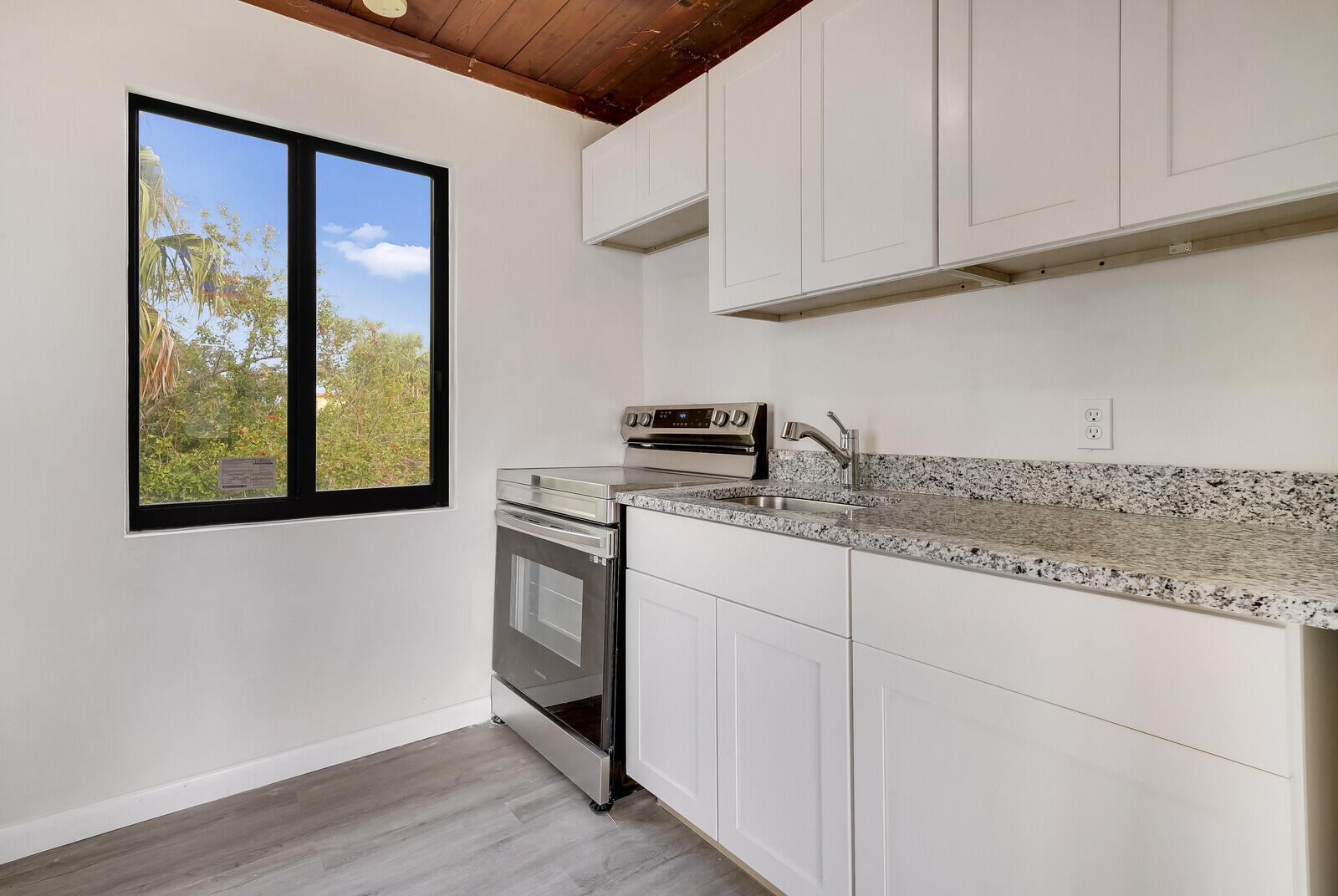 652 Hernando Street, Unit C Fort Pierce, FL 34949 - Photo 5 of 18 a kitchen with stainless steel appliances granite countertop a sink a stove and cabinets