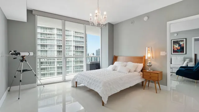 a bedroom with a bed and a chandelier