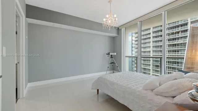 a bedroom with a bed and a chandelier