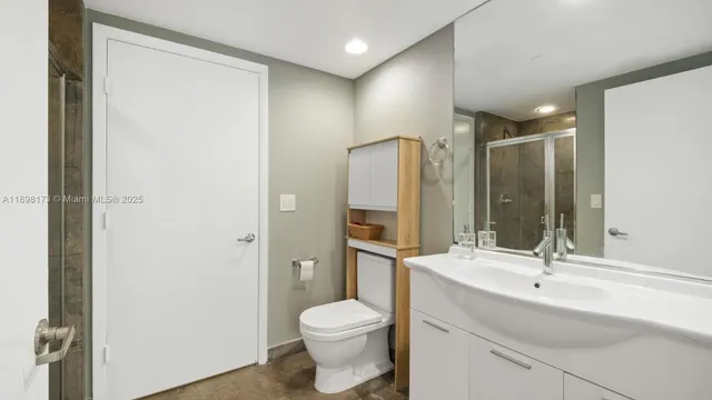 a bathroom with a sink toilet a mirror and shower