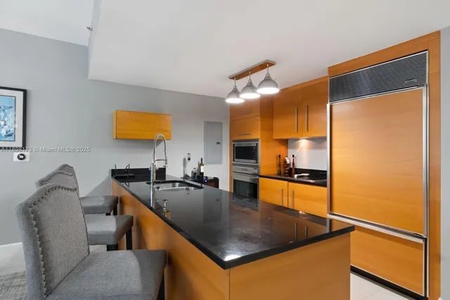 a kitchen with stainless steel appliances granite countertop a sink a stove and a refrigerator