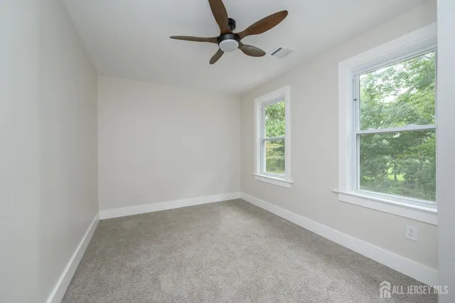 an empty room with a window and a fan