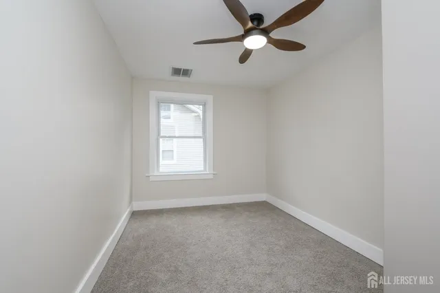 an empty room with a window and a fan